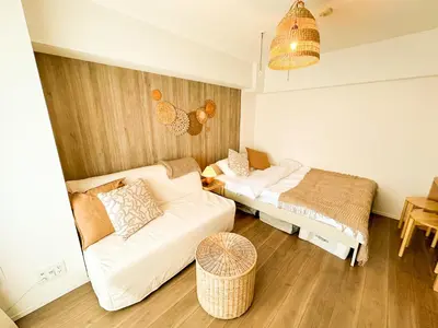a living room with a couch and a bed at Syforme Keikyu-Kamata Residence in Tokyo