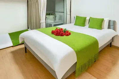 a hotel room with a bed with red roses on it at 406Room,With elevator, 700m 4 min walk from Nishi-Shinjuku 5-chome, direct access to Shinjuku, 28 sqm in Tokyo