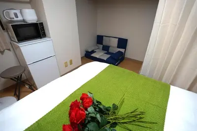 a bedroom with a bed with a flower on it at 406Room,With elevator, 700m 4 min walk from Nishi-Shinjuku 5-chome, direct access to Shinjuku, 28 sqm in Tokyo