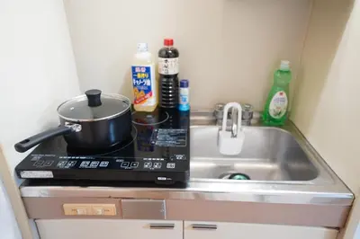 a kitchen counter with a stove and a sink at 406Room,With elevator, 700m 4 min walk from Nishi-Shinjuku 5-chome, direct access to Shinjuku, 28 sqm in Tokyo