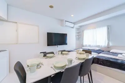 a white room with a table and chairs and a bed at feel Akihabara STAY in Tokyo