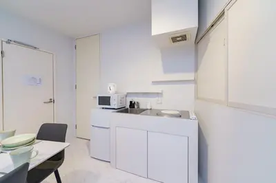 a white kitchen with a table and a microwave at feel Akihabara STAY in Tokyo