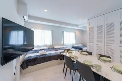 a room with two beds and a table with chairs at feel Akihabara STAY in Tokyo