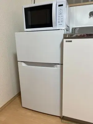 a microwave sitting on top of a refrigerator at HOTEL Japonica ANX in Tokyo