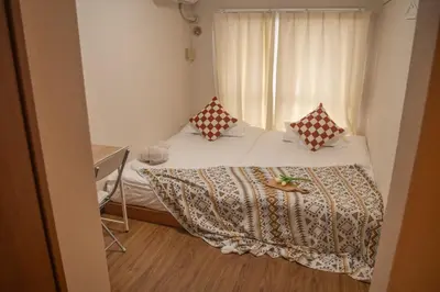 a small bedroom with a bed and a window at Shinjuku 2 stops Higashinakano three people in Tokyo