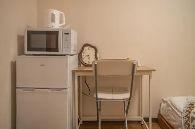 a desk with a chair and a microwave on top of it at Shinjuku 2 stops Higashinakano three people in Tokyo