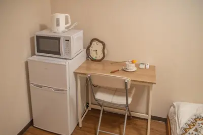 a small table with a microwave and a chair at Shinjuku 2 stops Higashinakano three people in Tokyo