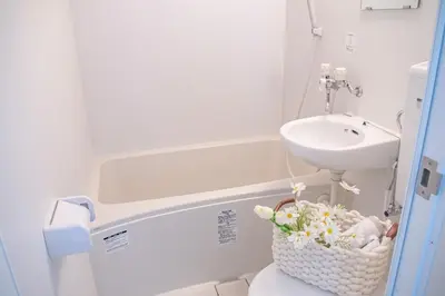 a bathroom with a sink and a basket of flowers on a toilet at Shinjuku 2 stops Higashinakano three people in Tokyo