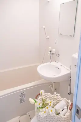a bathroom with a sink and a basket of toiletries at Shinjuku 2 stops Higashinakano three people in Tokyo