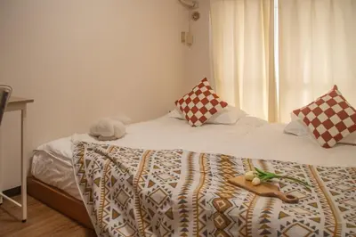 a bedroom with a bed with a tray on it at Shinjuku 2 stops Higashinakano three people in Tokyo