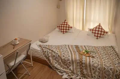 a small bedroom with a bed and a desk at Shinjuku 2 stops Higashinakano three people in Tokyo