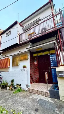 a house with a red door and a balcony at \u5d50-\u6c60\u888b4\u5206\u65b0\u5bbf15\u5206 in Tokyo