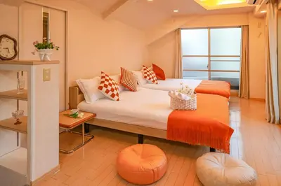 a bedroom with two beds with orange and white pillows at Shinjuku 2 stops 3 bedrooms best groups or family in Tokyo