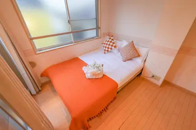 a small bed in a room with a window at Shinjuku 2 stops 3 bedrooms best groups or family in Tokyo