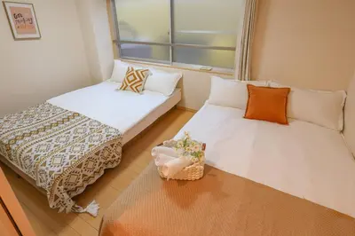 two beds in a small room with a window at Shinjuku 2 stops 3 bedrooms best groups or family in Tokyo