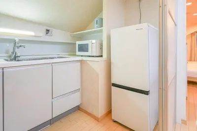 a white kitchen with a refrigerator and a sink at Shinjuku 2 stops 3 bedrooms best groups or family in Tokyo