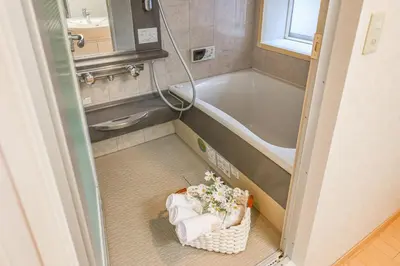 a bathroom with a tub and a basket of flowers at Shinjuku 2 stops 3 bedrooms best groups or family in Tokyo