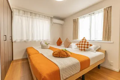 two beds in a room with two windows at ikebukuro three storey villa,three bedrooms,9-10 people in Tokyo
