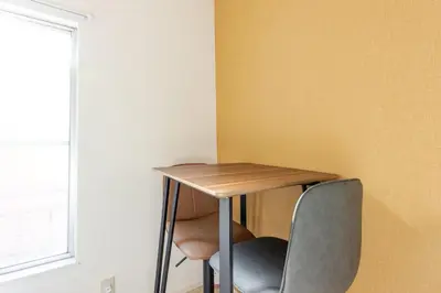 a table and two chairs sitting next to a wall at ksf\u6c60\u888b\u672c\u753a4\u4e01\u76ee in Tokyo