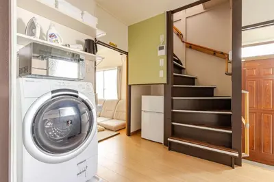 a washing machine in a room with a staircase at ksf\u6c60\u888b\u672c\u753a4\u4e01\u76ee in Tokyo
