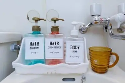 a bathroom sink with two bottles of soap and a cup at Keiko House in Tokyo