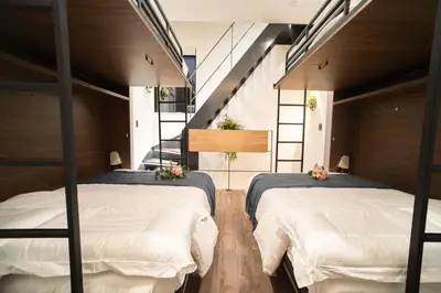 two beds in a room with a staircase at \u30dc\u30eb\u30bf\u30e9\u6e0b\u8c37 in Tokyo