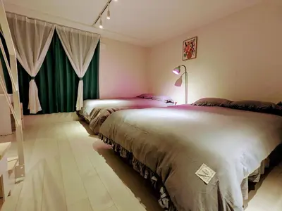 two beds in a room with green curtains at Ciel de Kagurazaka Familial iidabashi \u65b0\u5bbf\u795e\u697d\u5742\u98ef\u7530\u6a4b ## Shuttle, Ticket, Restaurant reservation service ## in Tokyo