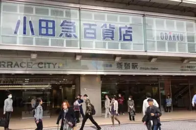 a group of people walking in front of a store at \u65b0\u5bbf\u99c5\u307e\u30672\u5206\u65b0\u5927\u4e45\u4fdd\u6238\u5efa\u30663br in Tokyo