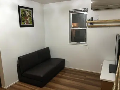 a living room with a black couch and a window at \u65b0\u5bbf\u99c5\u307e\u30672\u5206\u65b0\u5927\u4e45\u4fdd\u6238\u5efa\u30663br in Tokyo