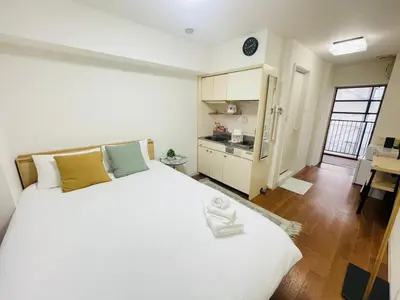 a bedroom with a large white bed and a kitchen at ying-Shinjuku hostel-SJ0055 in Tokyo