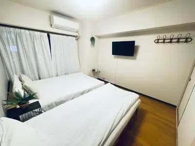 two beds in a room with a window and a tv at ying-Shinjuku hostel-SJ0055 in Tokyo