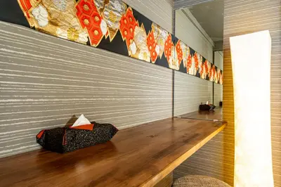 a hallway with a wooden floor and a wall with kites at The Guest House Sakura in Tokyo