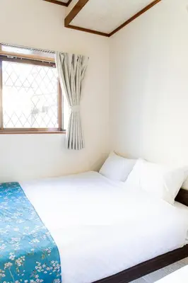 a bedroom with a bed and a window at The Guest House Sakura in Tokyo