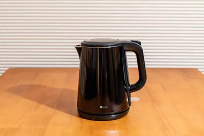 a black coffee cup sitting on a wooden table at The Guest House Sakura in Tokyo