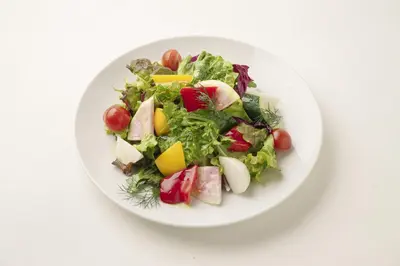 a white plate with a salad on a white table at Luce Stay&Resort Evoluto101 in Urayasu