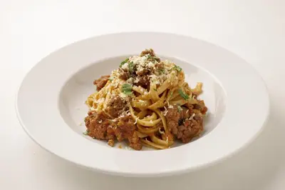 a white plate of pasta with meatballs and cheese at Luce Stay&Resort Evoluto101 in Urayasu