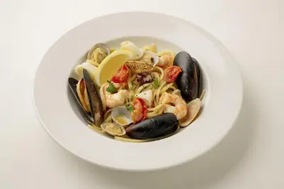 a bowl of seafood pasta with shrimp and mussels at Luce Stay&Resort Evoluto101 in Urayasu