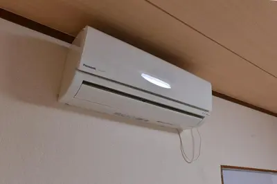 a white air conditioner hanging from a ceiling at Joyfull House in Tokyo