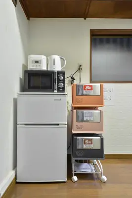 a pile of appliances sitting on top of a refrigerator at Joyfull House in Tokyo