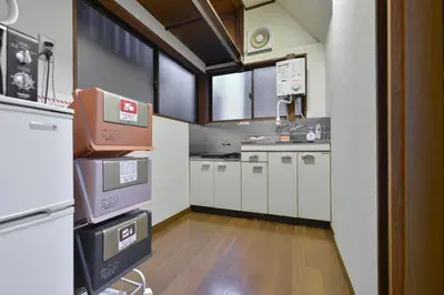a large kitchen with white cabinets and a large window at Joyfull House in Tokyo