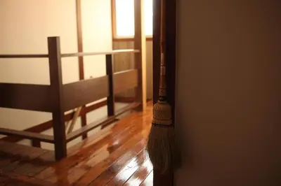 a broom hanging on a wall next to a chair at Edo Tokyo Sharehouse Long Stay Only, One month plus in Tokyo