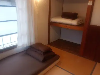 a room with two stacks of towels and a window at Edo Tokyo Sharehouse Long Stay Only, One month plus in Tokyo