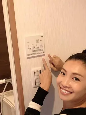 a young woman is pointing to a lightswitch at \u30dc\u30f3\u30a2\u30fc\u30c8\u702c\u7530 in Tokyo