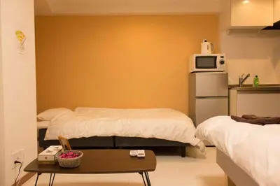 a small room with two beds and a table at \u30dc\u30f3\u30a2\u30fc\u30c8\u702c\u7530 in Tokyo