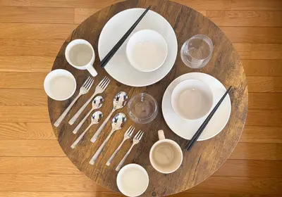 a table with white plates and utensils on a table at Shinjuku Vintage Rooftop Terrace Stay in Tokyo