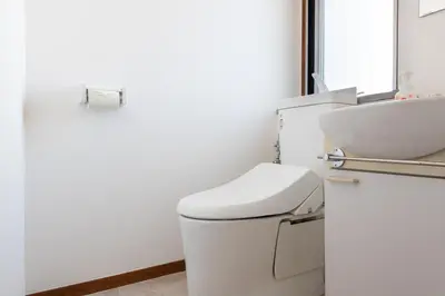 a white bathroom with a toilet and a sink at Shinjuku Vintage Rooftop Terrace Stay in Tokyo