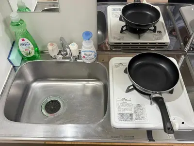 a kitchen sink with a frying pan on a stove at Shinjuku Cloudlive AH in Tokyo
