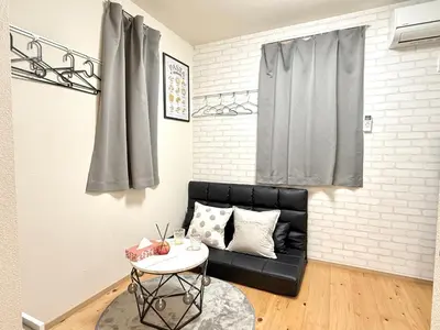 a living room with a black couch and a table at Shinjuku Cloudlive AH in Tokyo