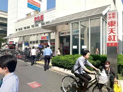 a man riding a bike in front of a store at Monzennakacho Royal Residence in Tokyo