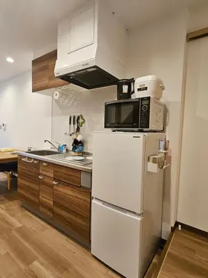 a kitchen with a white refrigerator and a microwave at Asakusa Stay \u897f\u6d45\u8349 in Tokyo